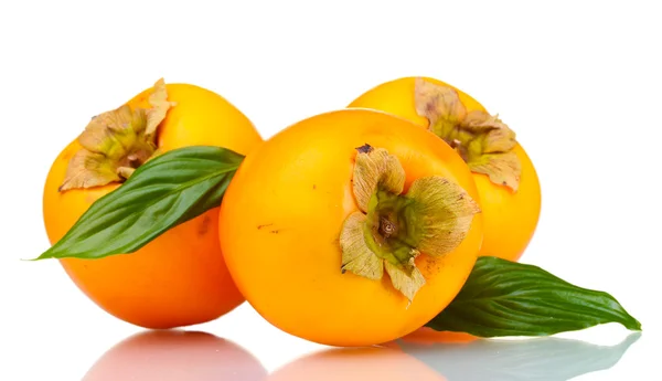 Three appetizing persimmons with green leaves isolated on white — Stock Photo, Image