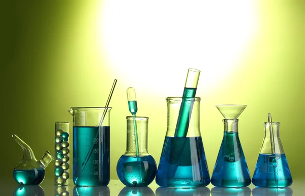 녹색 배경에 파란색 액체와 시험관 — 스톡 사진