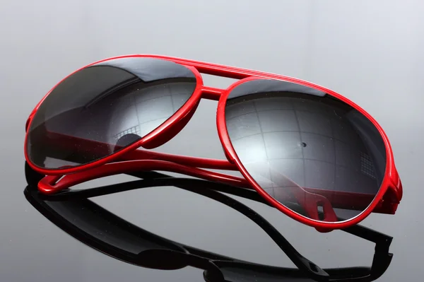Mulheres glamourosas óculos de sol vermelhos no fundo cinza — Fotografia de Stock