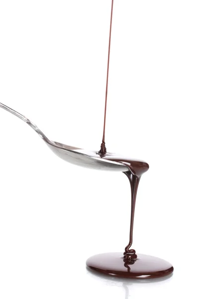 Шоколад вливають у ложку ізольовано на білому — стокове фото