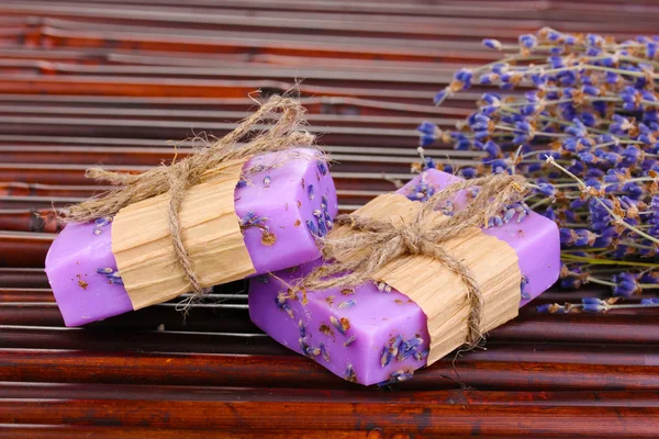 Лавандовое мыло ручной работы на бамбуковом коврике — стоковое фото