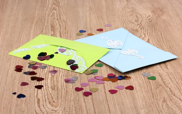 Kleur enveloppen en confetti op houten achtergrond — Stockfoto