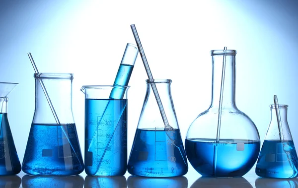 파란색 배경에 파란색 액체와 시험관 — 스톡 사진