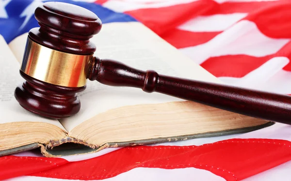 Soudce kladívkem a kniha na pozadí americké vlajky — Stock fotografie