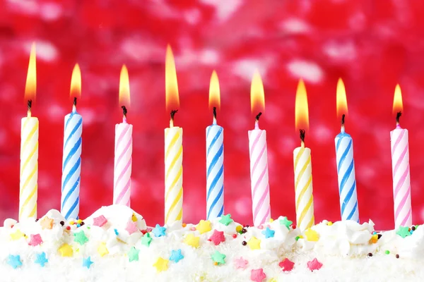 Mooie birthday kaarsen op rode achtergrond — Stockfoto
