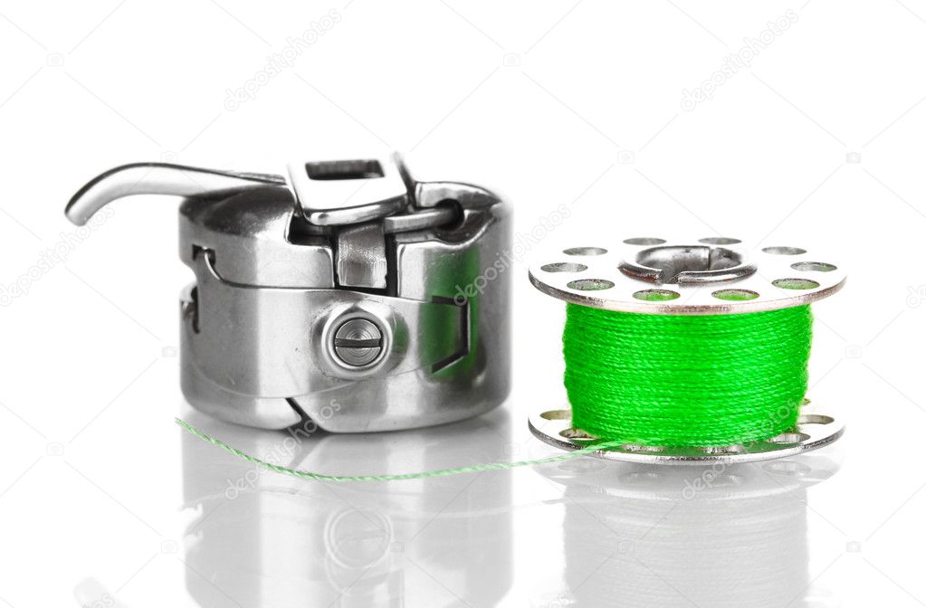 Metal spool of thread and sewing machine shuttle isolated on white