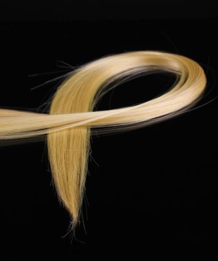 Shiny blond hair isolated on black clipart