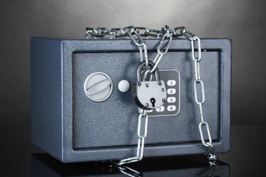 Safe with chain and lock on grey background clipart