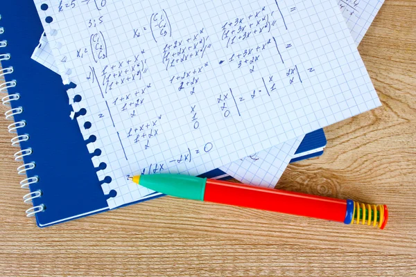 Math on copybook page on a wooden table — Stock Photo, Image