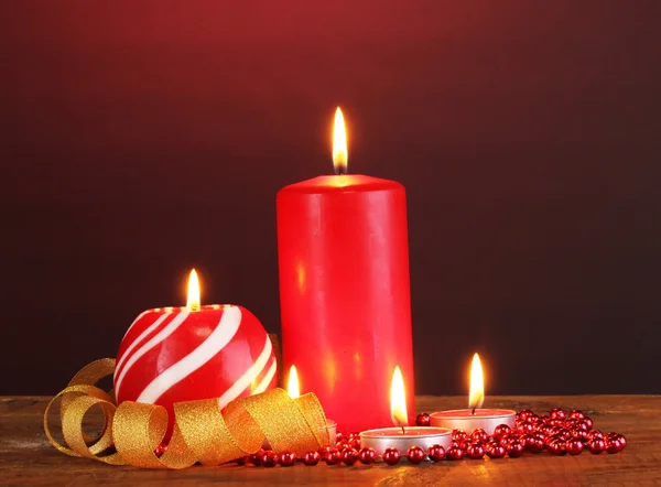 Merveilleuses bougies sur table en bois sur fond sombre — Photo