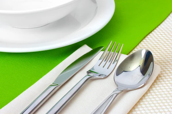Ajuste de mesa con tenedor, cuchillo, cuchara, platos y servilleta —  Fotos de Stock