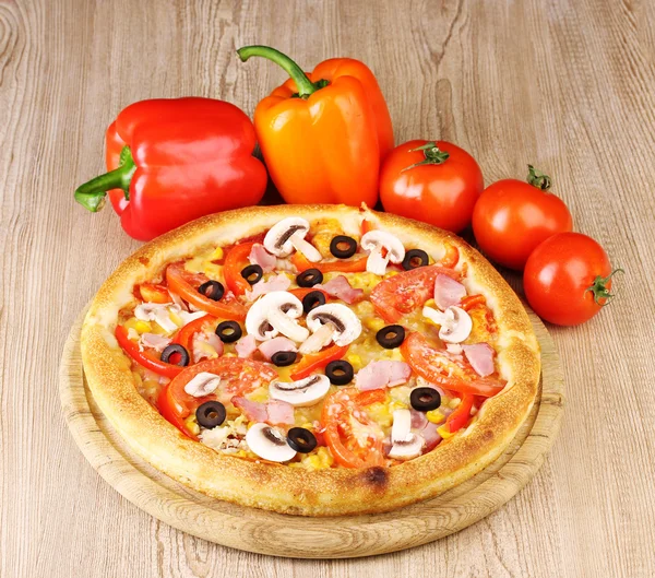 Aromatic pizza with vegetables on wooden background — Stock Photo, Image