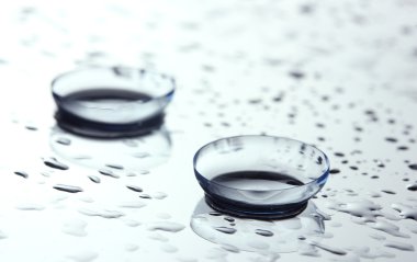 Contact lens with drops on white background clipart