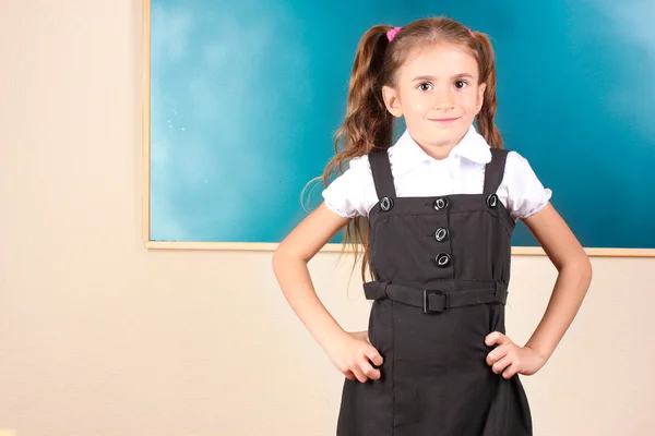 漂亮的小女孩站在教室里的黑板旁边 — 图库照片
