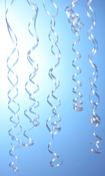 Schöne Luftschlangen auf blauem Hintergrund — Stockfoto
