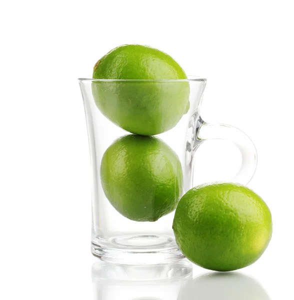 Limes fraîches dans une tasse en verre isolé sur blanc — Photo