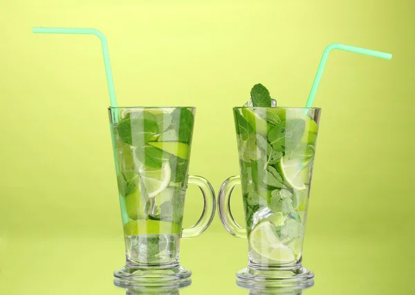 Vasos de cóctel con lima y menta sobre fondo verde —  Fotos de Stock