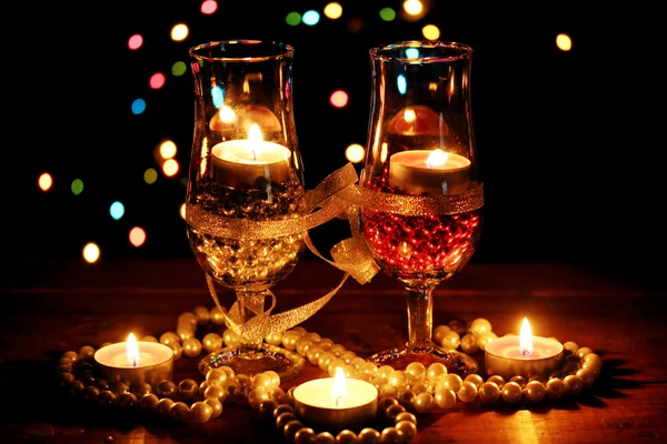 Incredibile composizione di candele e bicchieri su tavolo di legno su sfondo luminoso — Foto Stock