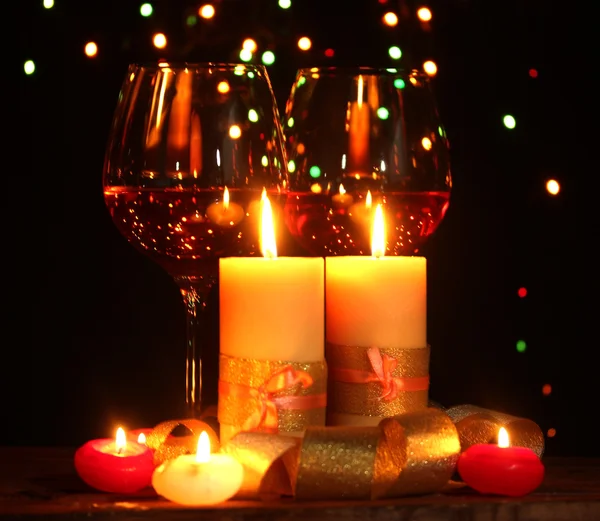 Bela vela e copos de vinho na mesa de madeira em fundo brilhante — Fotografia de Stock