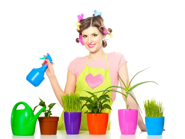 Mooie gelukkig jonge huisvrouw sprays planten in bloempotten geïsoleerd op wit — Stockfoto