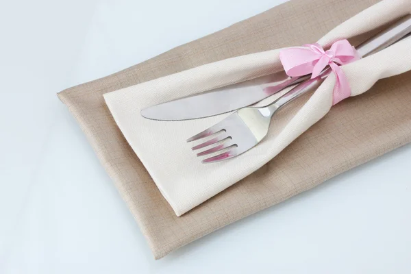 Forchetta e coltello su tovagliolo isolato su bianco — Foto Stock