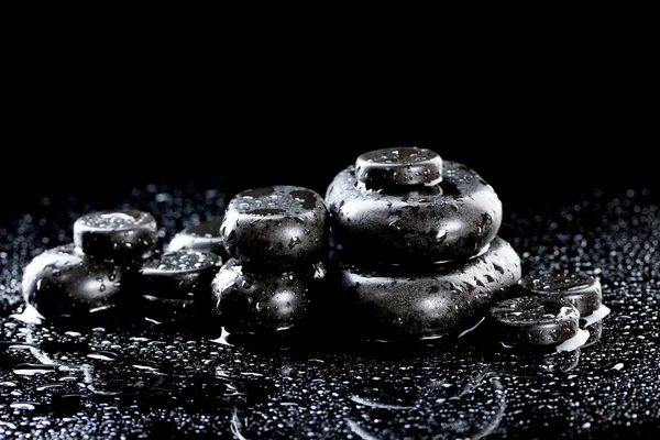 Piedras de spa con gotas sobre fondo negro — Foto de Stock
