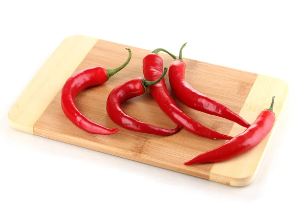 Red hot chili peppers on wooden plank isolated on white — Stock Photo, Image