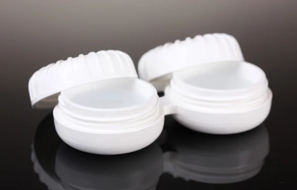Contact lenses in containers on grey background — Stock Photo, Image