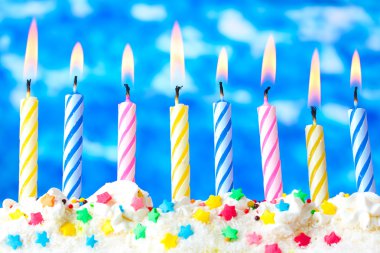 Beautiful birthday candles on blue background clipart