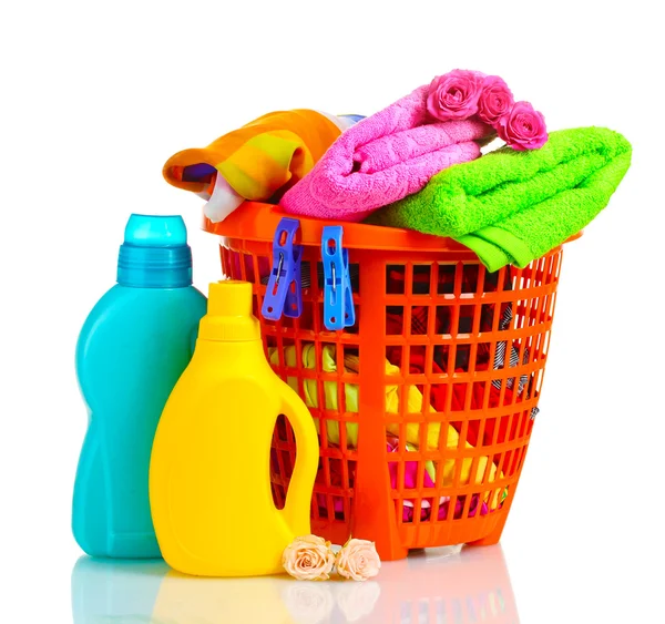 Ropa con detergente en cesta de plástico naranja aislada en blanco —  Fotos de Stock