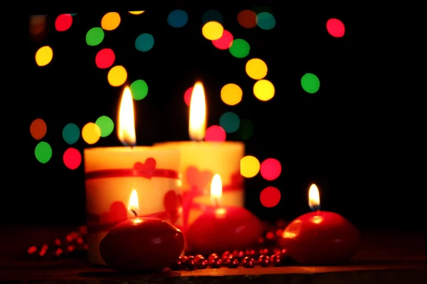 Schöne Kerzen auf Holztisch auf hellem Hintergrund — Stockfoto