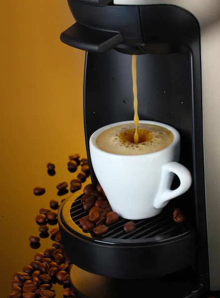 stock image Espresso machine pouring coffee in cup on brown background