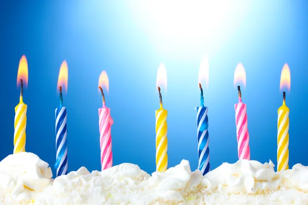 Hermosas velas de cumpleaños sobre fondo azul — Foto de Stock