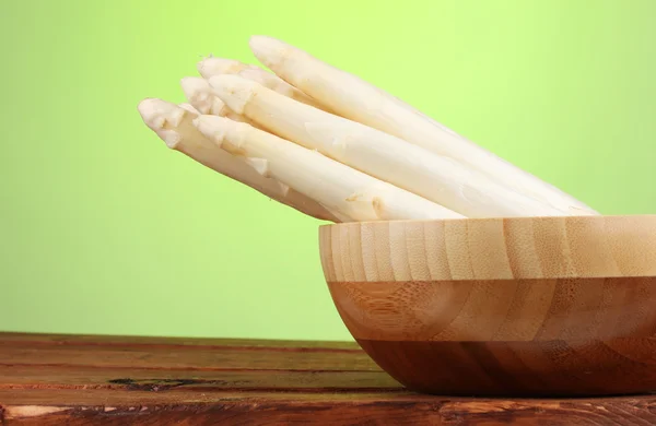 Belo espargos brancos em tigela na mesa de madeira no fundo verde — Fotografia de Stock
