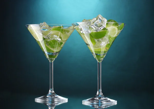 Glasögon av cocktails med lime och mynta på blå bakgrund — Stockfoto
