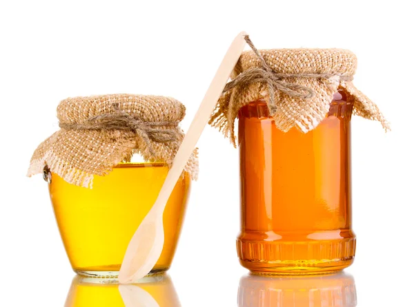 Miel dulce en frascos con cuchara aislada sobre blanco — Foto de Stock