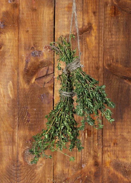 Fresh green thyme hanging on rope on wooden background — Stock Photo, Image