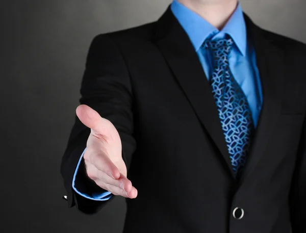 Üzletember ad a kezét egy fekete háttér kézfogás — Stock Fotó