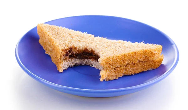 Укушенный бутерброд с шоколадом на тарелке изолирован на белом — стоковое фото