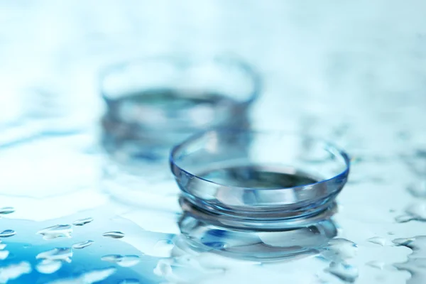 Contact lens with drops on blue background — Stock Photo, Image