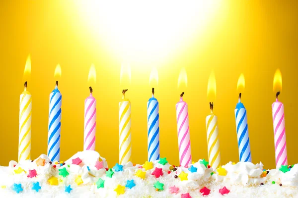 Belas velas de aniversário no fundo amarelo — Fotografia de Stock