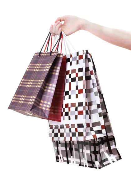 Mão feminina segurando sacos de compras brilhantes isolados no branco — Fotografia de Stock