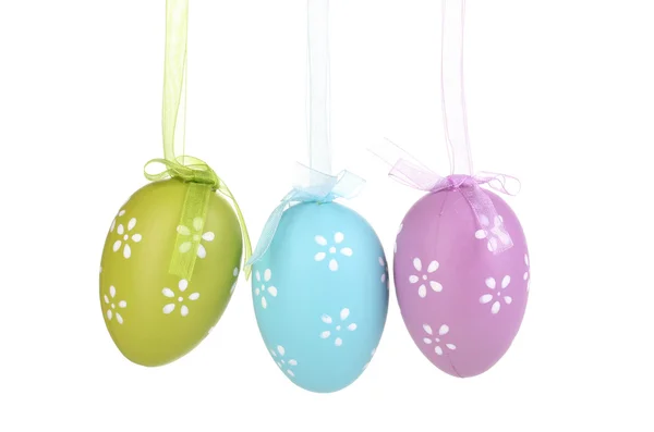 Coloridos huevos de Pascua colgados en cintas aisladas en blanco — Foto de Stock