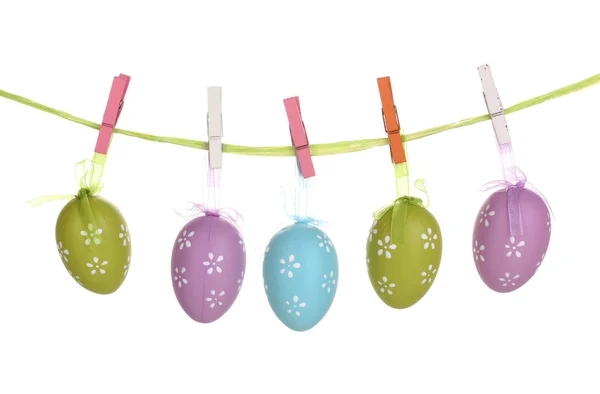 Œufs de Pâques colorés suspendus sur des rubans isolés sur du blanc — Photo