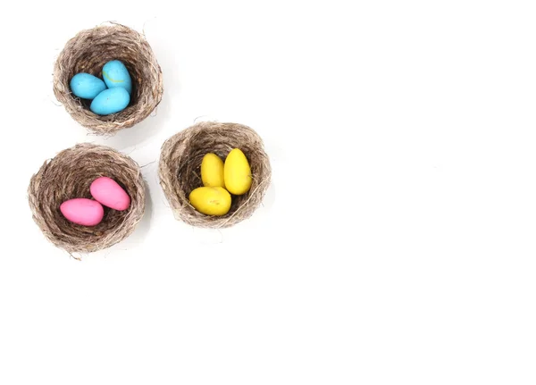 Colorful easter eggs in nests isolated on white — Stock Photo, Image