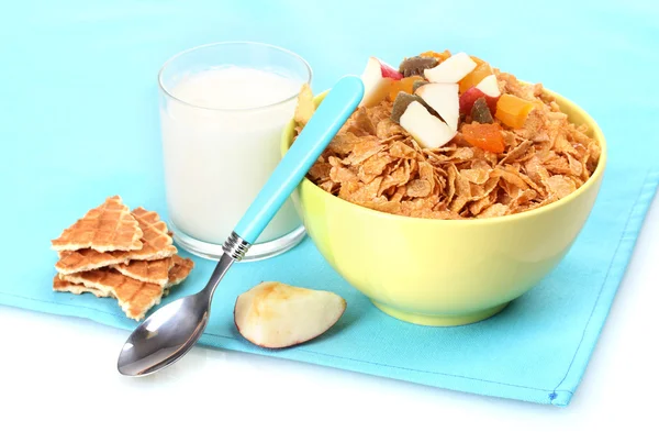 Flocos de milho saborosos em tigela com frutas secas e vidro de leite em guardanapo azul — Fotografia de Stock