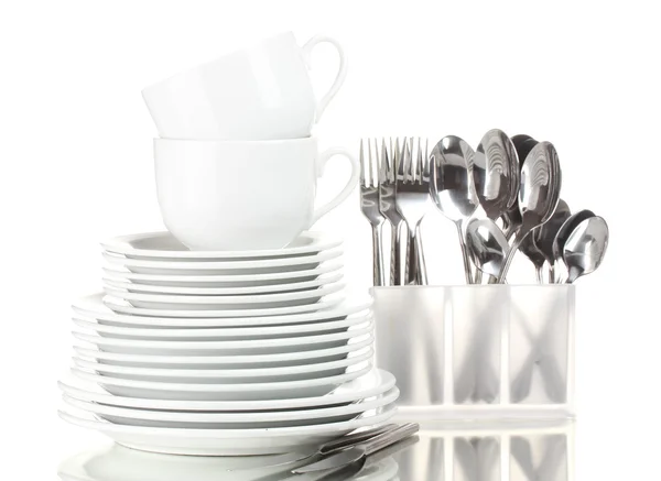 Чистые тарелки, чашки и столовые приборы изолированы на белом — стоковое фото