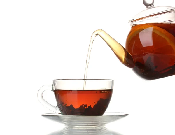 Szklany czajniczek wlanie czarnej herbaty do filiżanki izolowane na białym — Zdjęcie stockowe