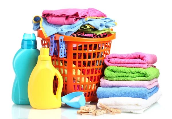 Roupas com detergente e pó de lavagem em cesta de plástico laranja, isoladas a branco — Fotografia de Stock