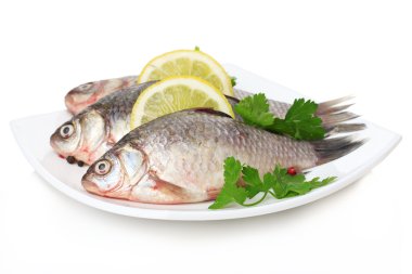 taze balıkları tabakta üzerine beyaz izole maydanoz ve limon ile